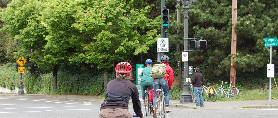 Cyclists riding toward a green bike signal