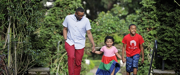 A family of color walks through a green park