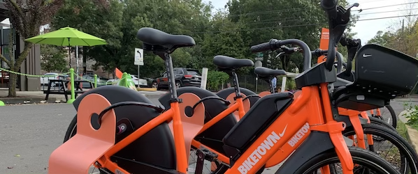 Orange BIKETOWN electric bikes docked at a BIKETOWN station in Portland, Oregon