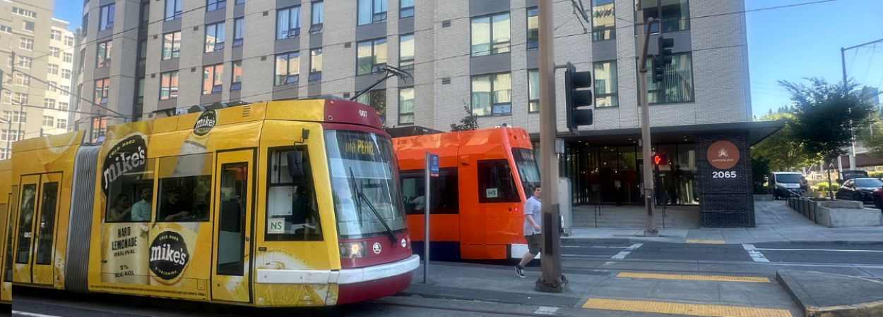 Photo of a transit-oriented development from the study with two Portland streetcars in front of it.