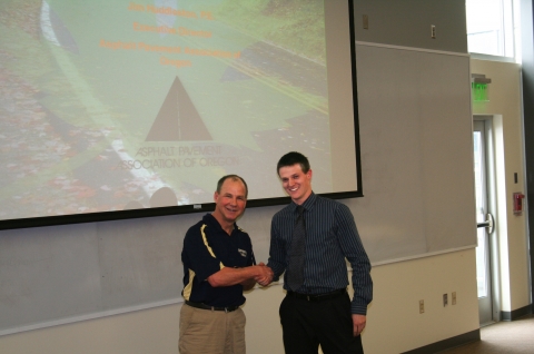 Jim Huddleston, left, executive director of the Asphalt Pavement Association of Oregon, congratulates Oregon Tech student Zachary Hudspeth on an award from the association. Huddleston spoke in Klamath Falls as the Oregon Tech NITC Visiting Scholar Feb. 21.