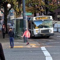 trimet bus at intersection with pedestrians crossing